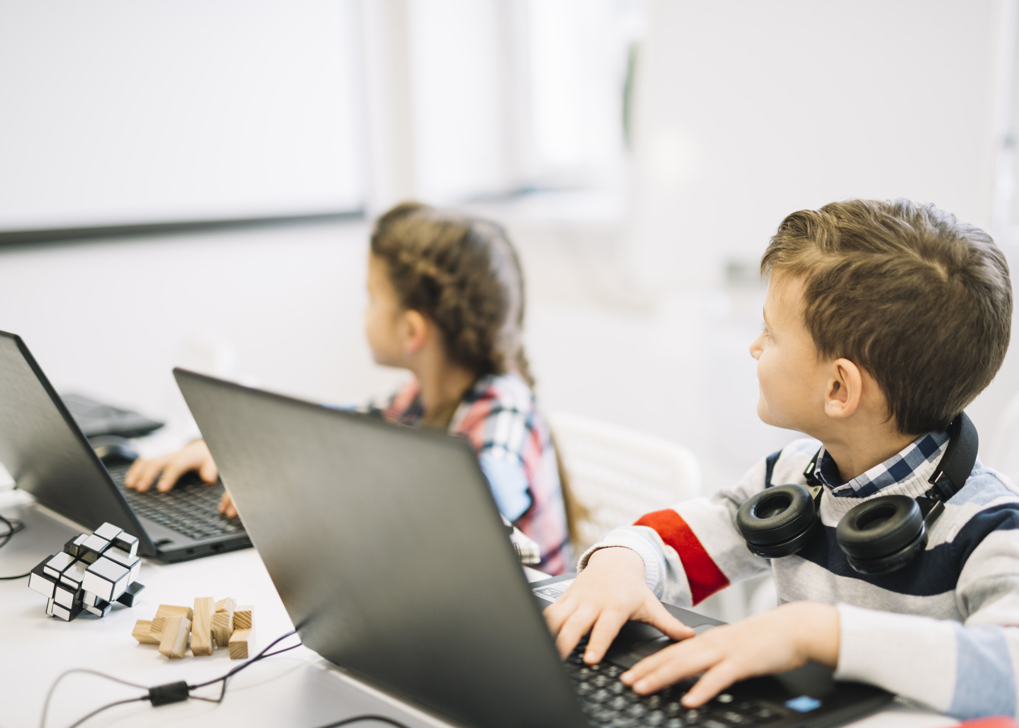 school-children-sitting-with-laptop-looking-at-blackboard.jpg