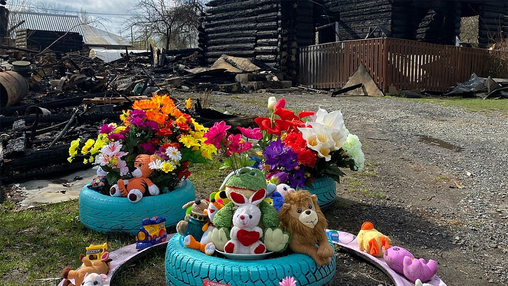 Жители владимирского поселка несут цветы и игрушки к сгоревшему дому, в котором в огне погиб ребенок